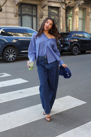 model draagt donker blauwe balloon jeans met blouse dames ladylike