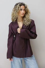 model poseert in bordeaux blazer met lichte jeans zijkant