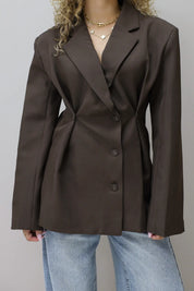 model draagt bruine blazer met jeans frontaal