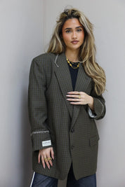 Close up van bruine geruite blazer met revers en borstzak