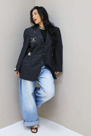 model staand in hoek met gestreepte vintage blazer