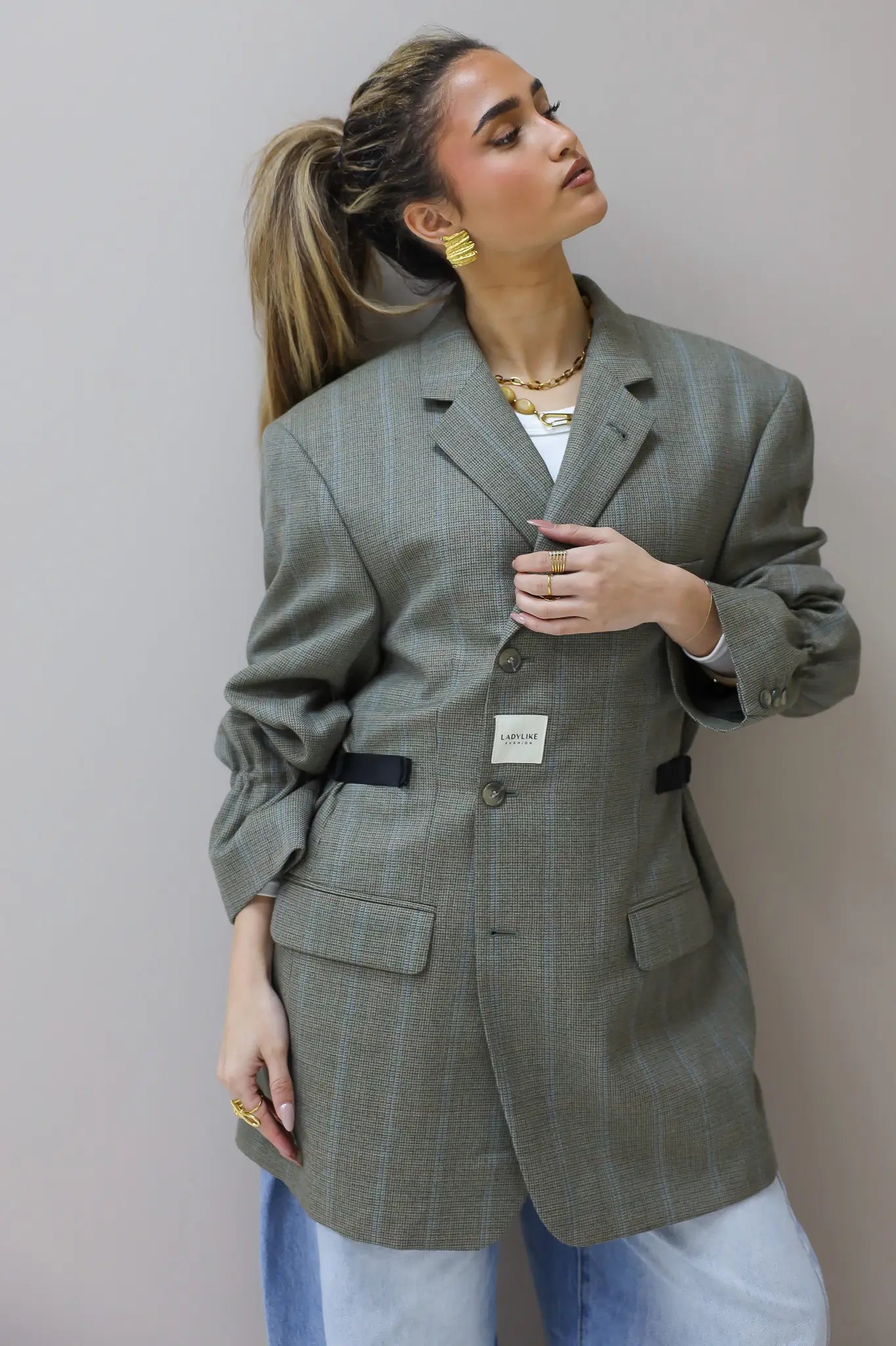 Model draagt Atelier Series reworked blazer grijs in close up met opgestroopte mouwen