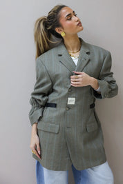 Model draagt Atelier Series reworked blazer grijs in close up met opgestroopte mouwen