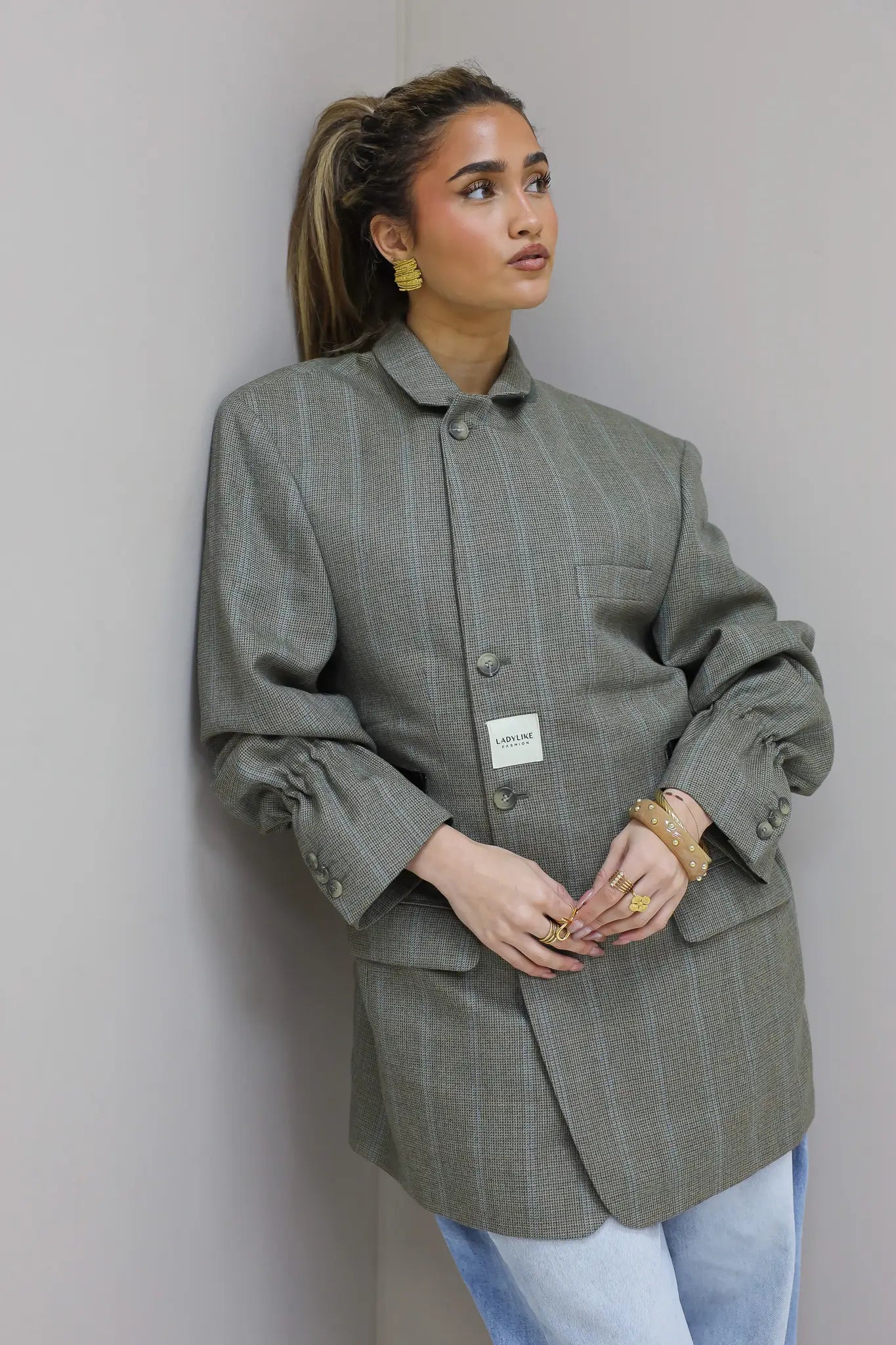 Close up van voorkant met knopen en borstzak van grijze blazer