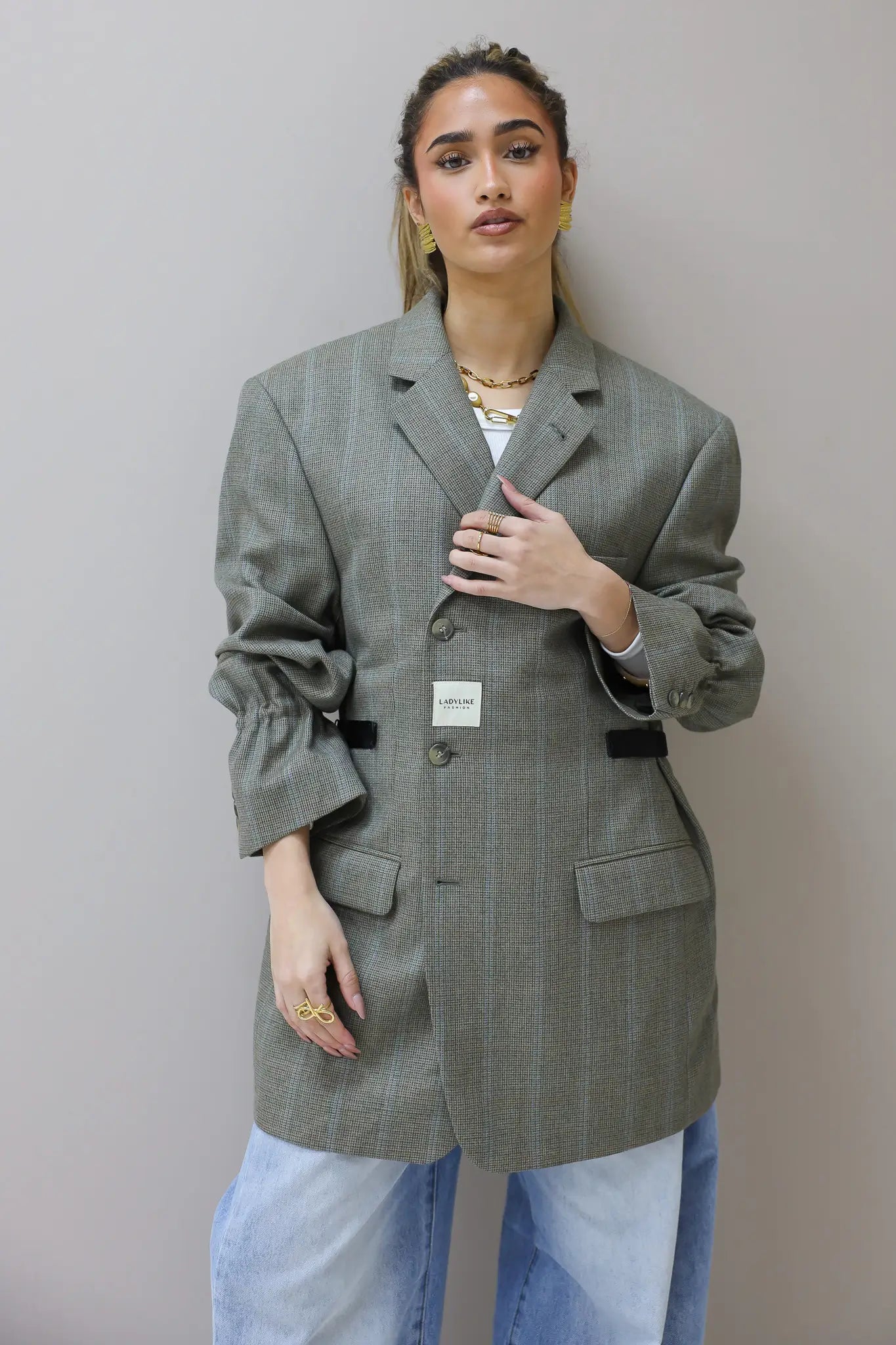 Model met hand bij de revers van grijze Atelier Series blazer