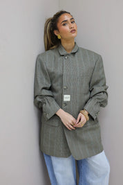 Model in ontspannen houding met grijze oversized blazer