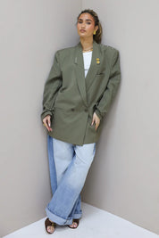 Rechtstaande look met groene reworked blazer en lichte denim