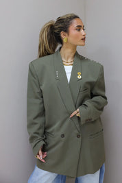 Zijaanzicht van groene oversized blazer gecombineerd met jeans