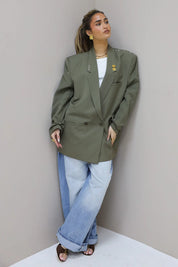 Model draagt oversized Atelier Series reworked blazer in groen met wijde jeans