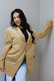 model poseert schuin met camel blazer