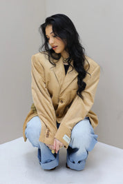 model zittend met camel blazer atelier series