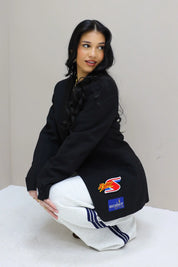 model poseert zittend met atelier series blazer zwart