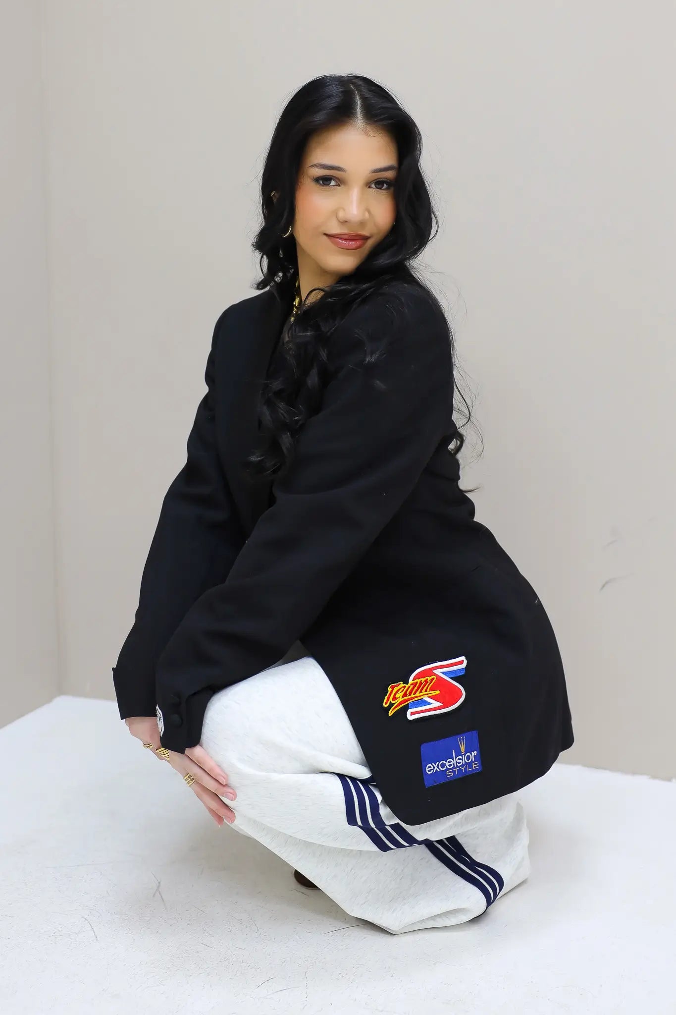 model zittend met zwarte blazer race patches