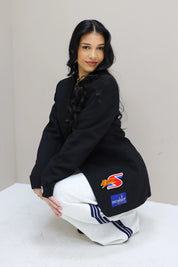 model zittend met zwarte blazer race patches