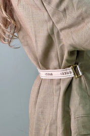 Detail van beige tailleband op de achterkant van de camel blazer