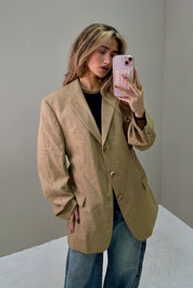 Model draagt Atelier Series reworked designer blazer camel in close up met zwarte top