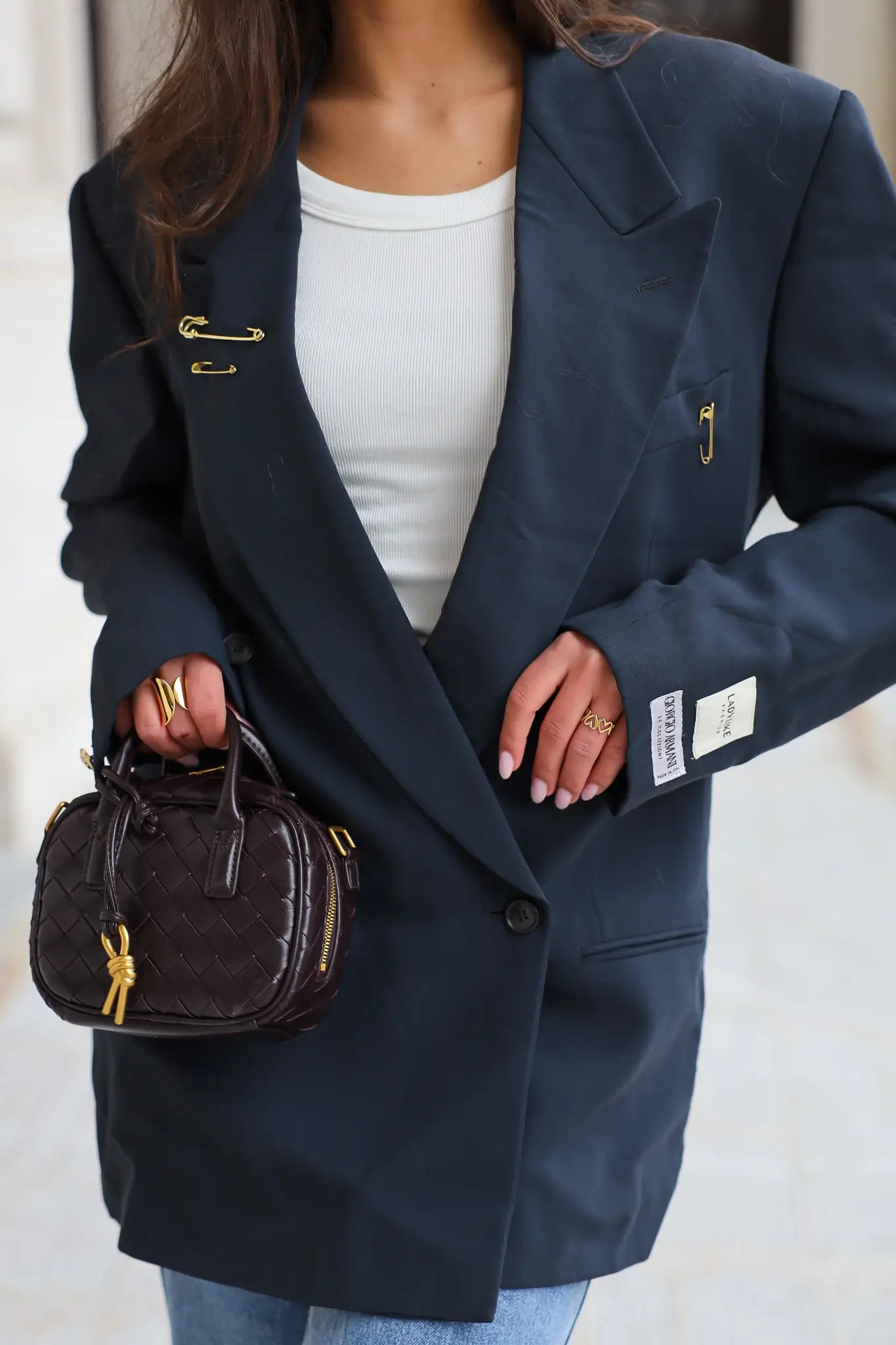 Detail van donker blauwe BOSS blazer met gouden accenten