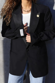 detail van borst en sluiting van zwarte blazer