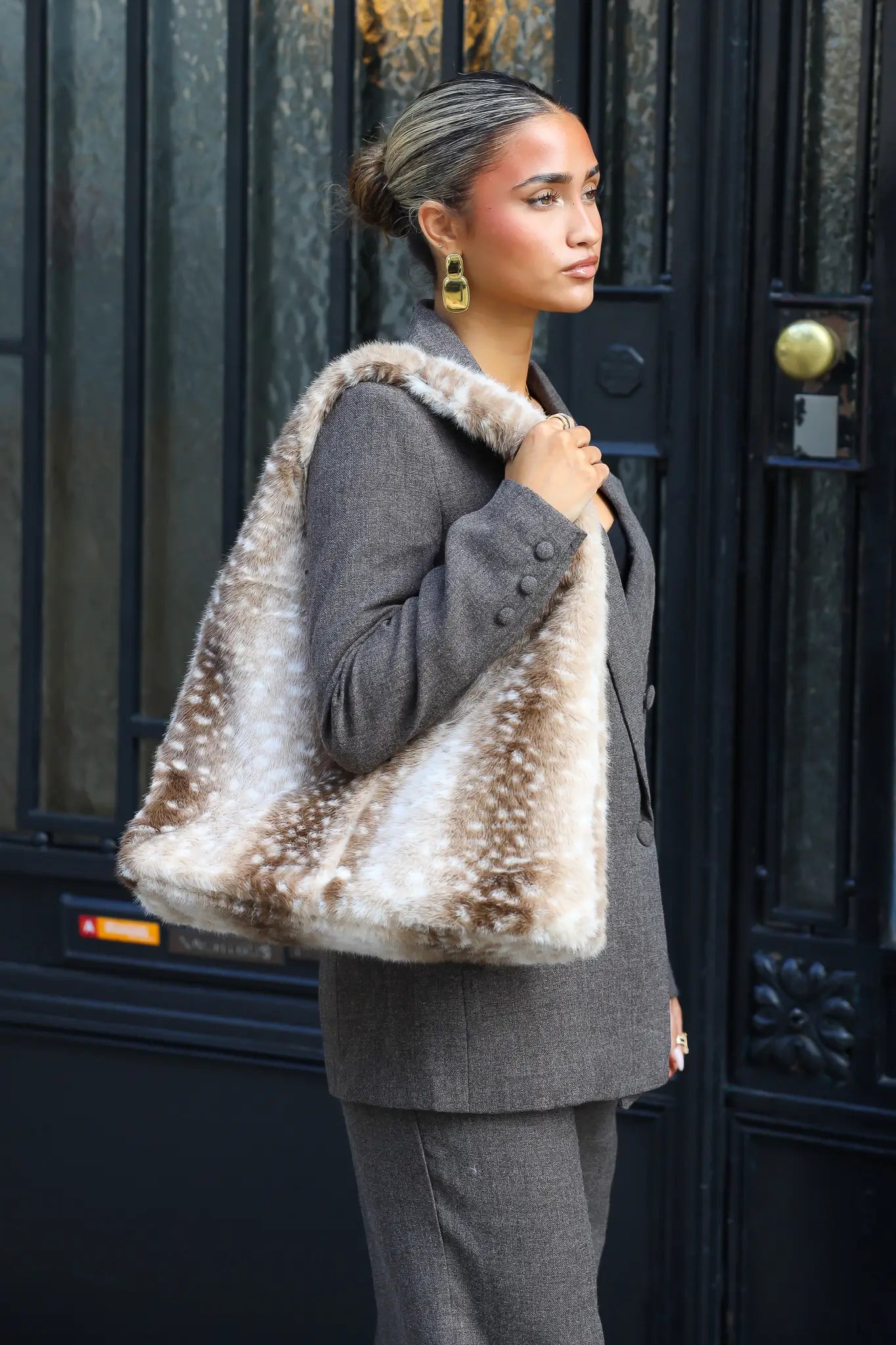 Zachte beige Bambi bonttas met bruine dierenprint en witte stippen gedragen over de schouder