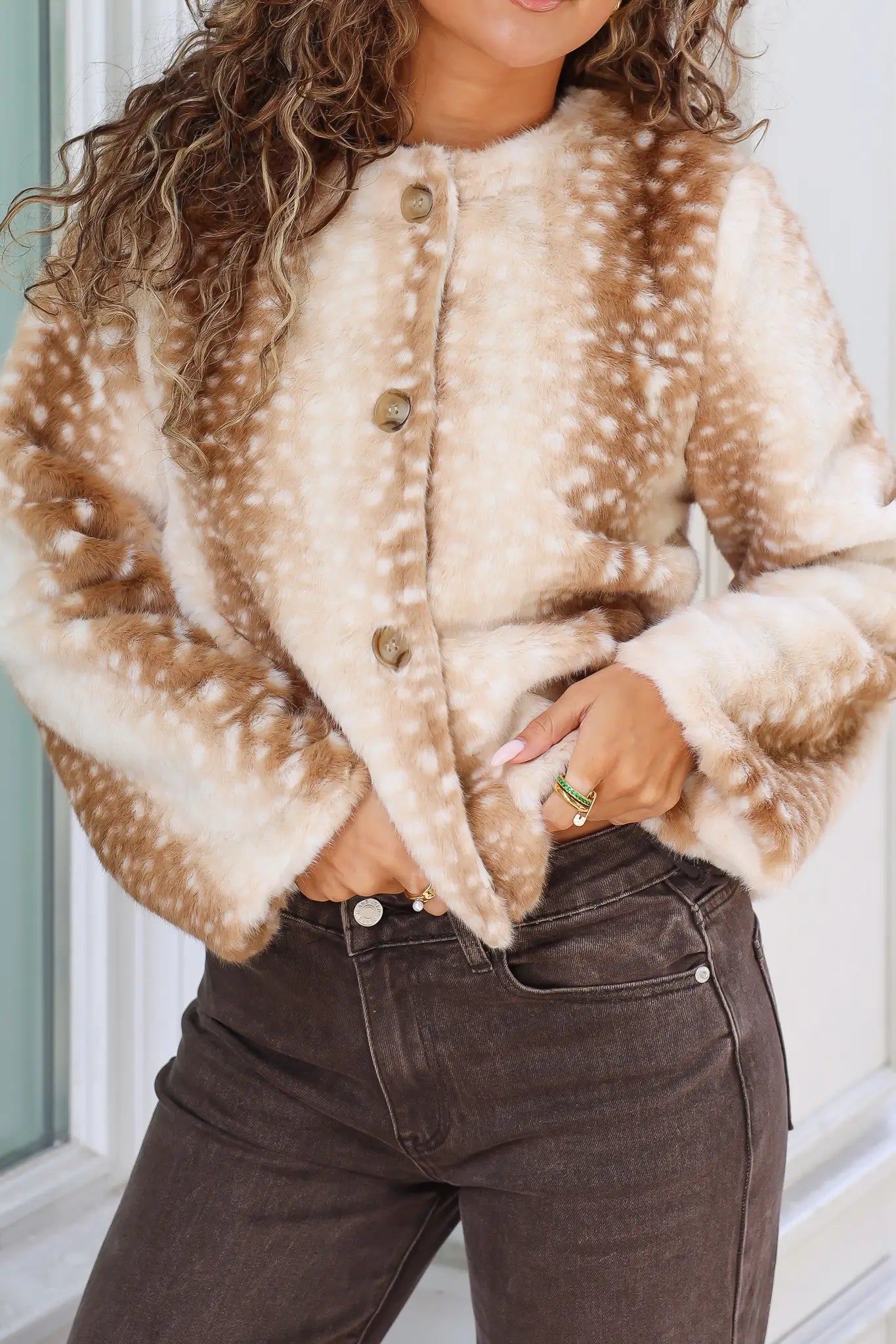 Close-up van camel Bambi jasje met zachte stof ronde hals knoopsluiting en bruine hertenprint met witte stippen