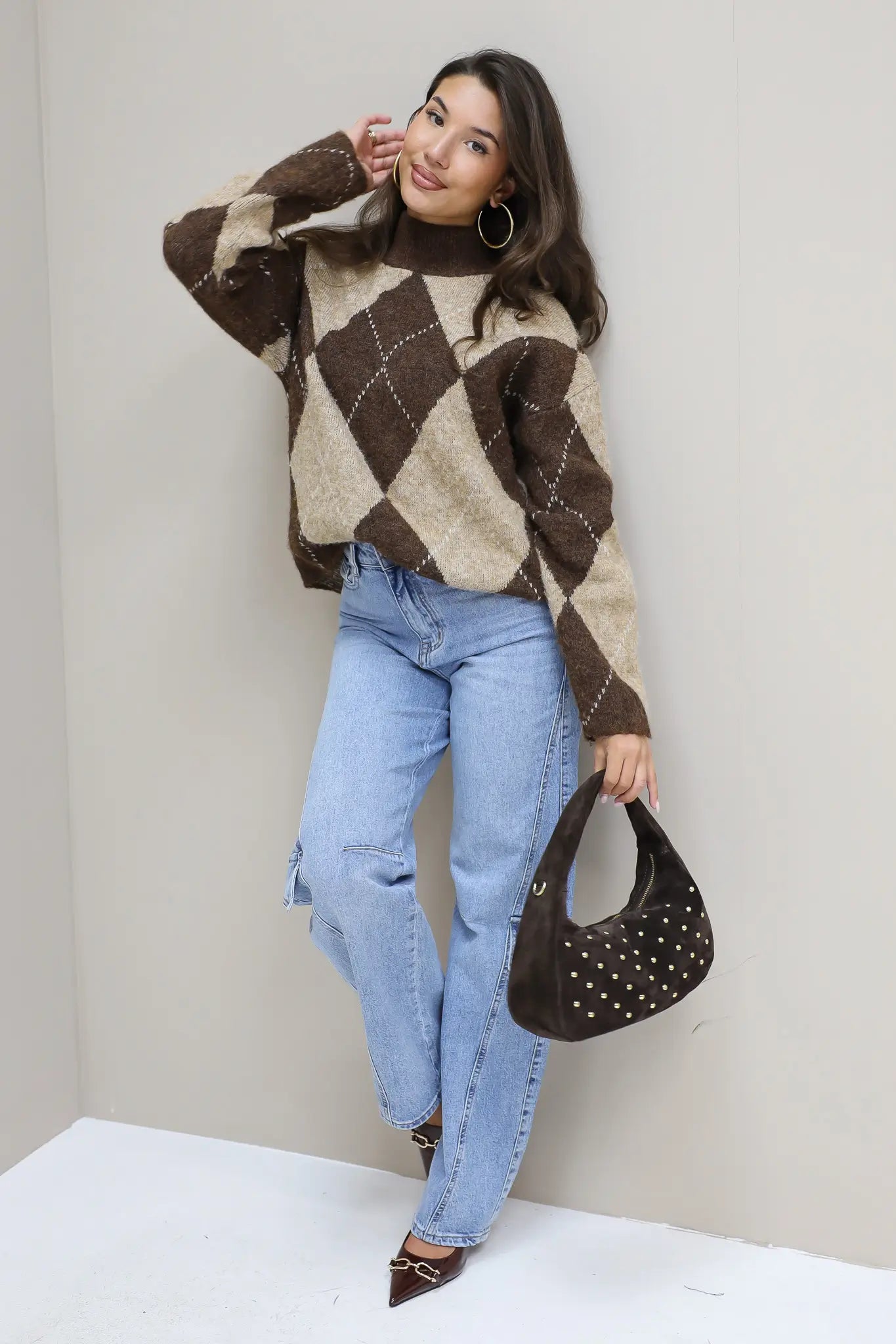 model in lichte barrel jeans met bruine trui