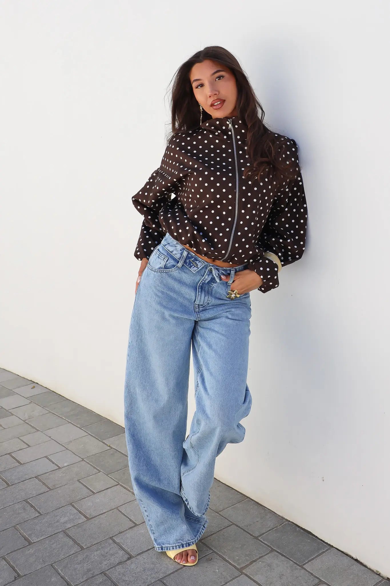 Model draagt barrel jeans omslag band blauw met zwarte top