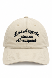 Beige baseball cap met zwart Los Angeles borduursel en gebogen klep op witte achtergrond