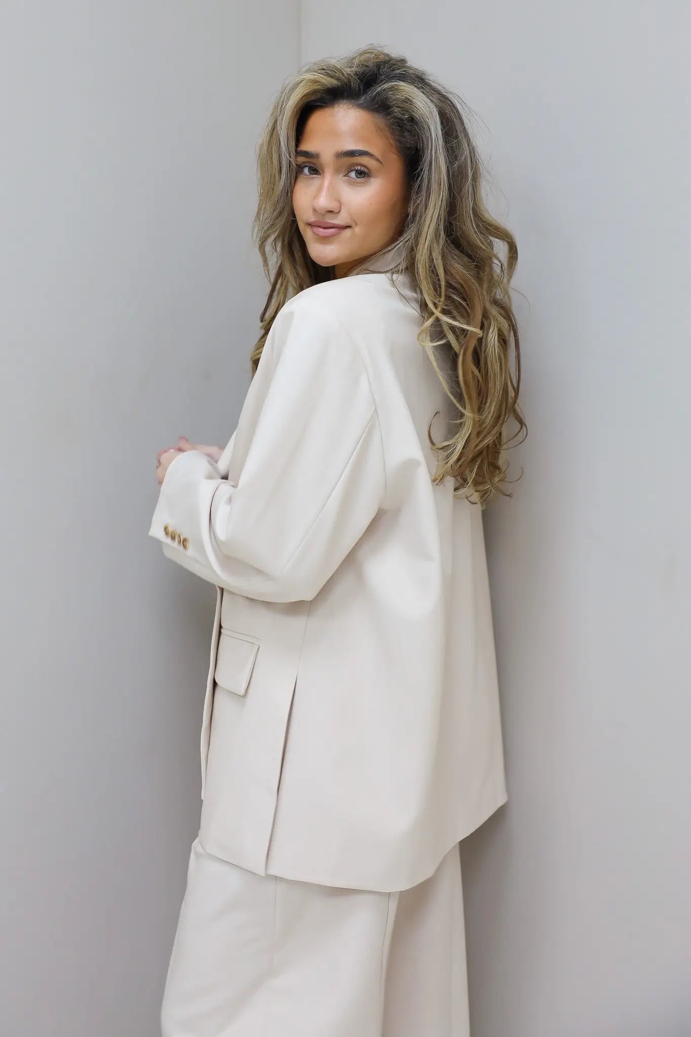 model draagt beige blazer dames achterkant ladylike