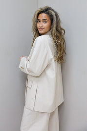 model draagt beige blazer dames achterkant ladylike