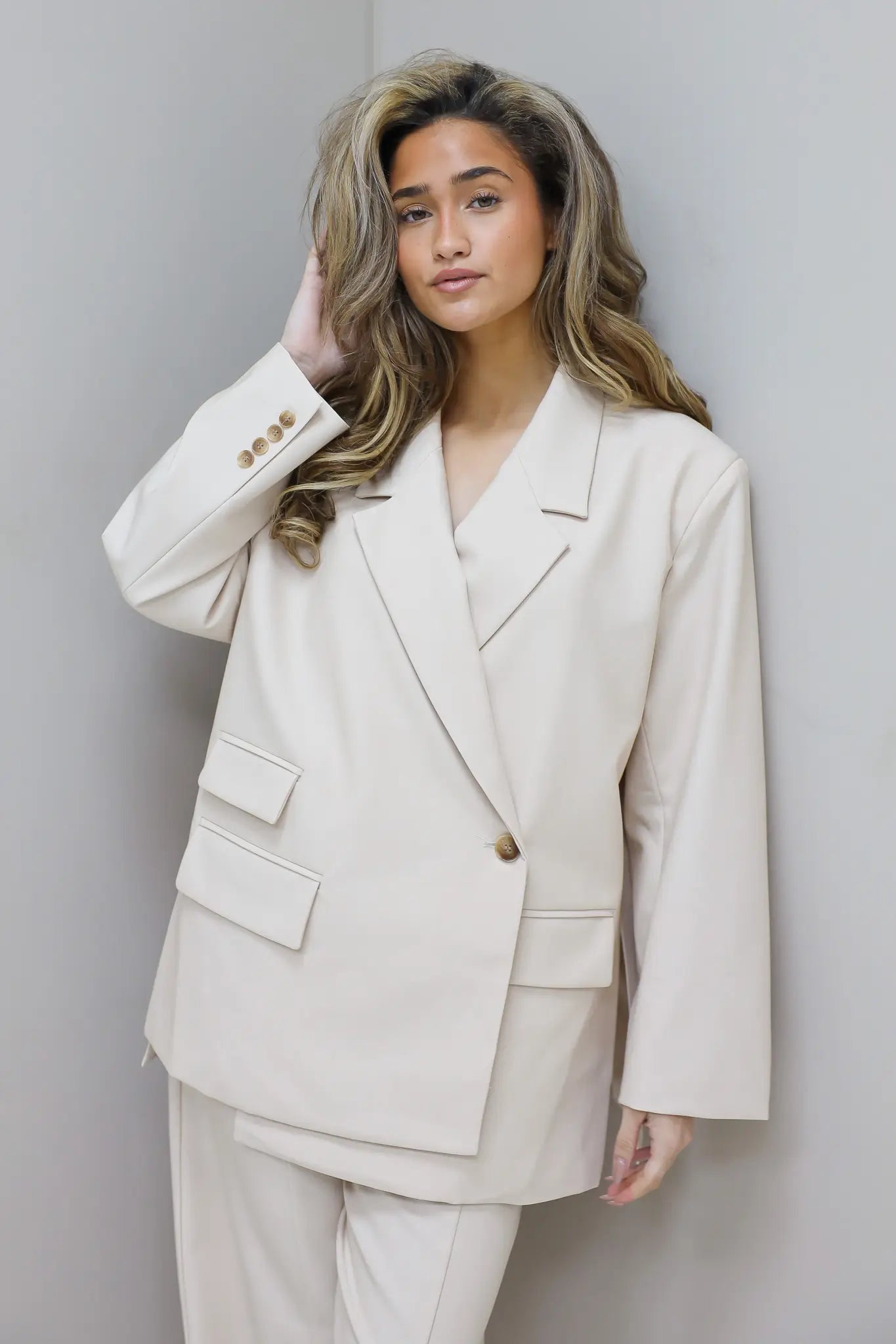 model draagt beige blazer dames studio foto ladylike