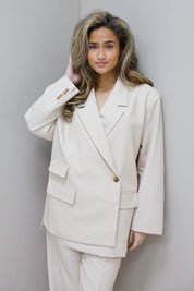 model draagt beige blazer dames studio pose ladylike