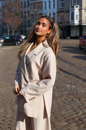 model draagt beige blazer dames zijkant ladylike