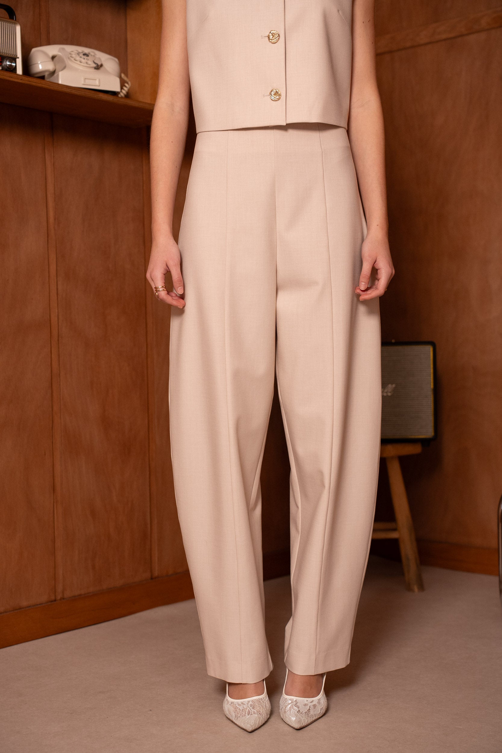 model draagt beige pantalon dames outfit ladylike