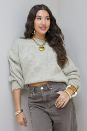 Model draagt beige cropped trui met bruine broek