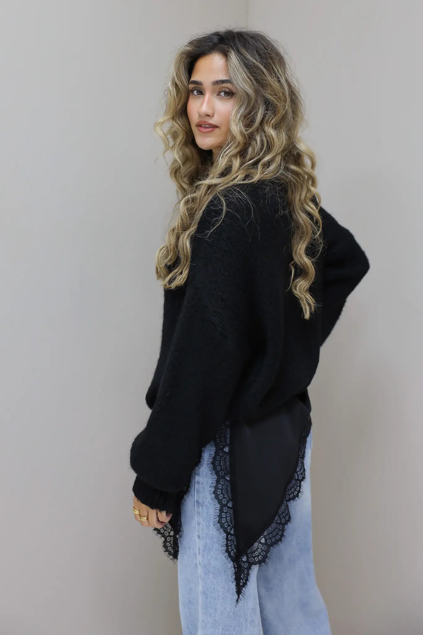 Zwarte trui met satijnen onderjurk van achteren gefotografeerd