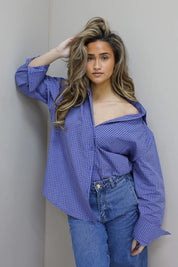 model draagt blauwe ruit blouse gecombineerd met jeans