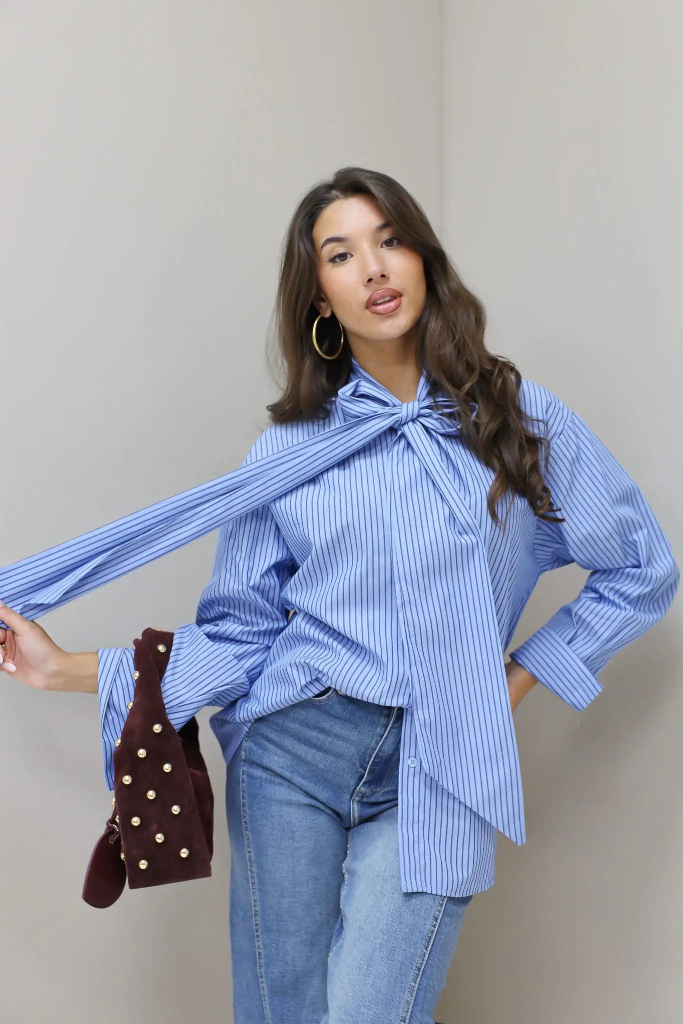 blauwe gestreepte blouse model licht gedraaid met tas