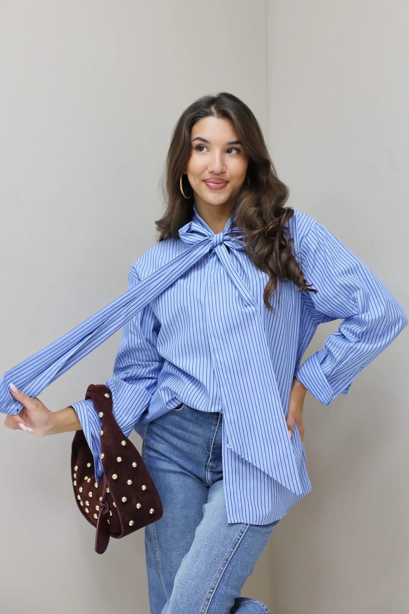 blauwe gestreepte blouse model vooraan met losse mouwen en tas
