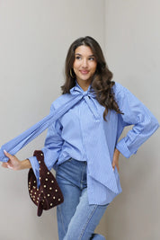 blauwe gestreepte blouse model vooraan met losse mouwen en tas