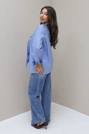 blauwe gestreepte blouse model in zijaanzicht met tas