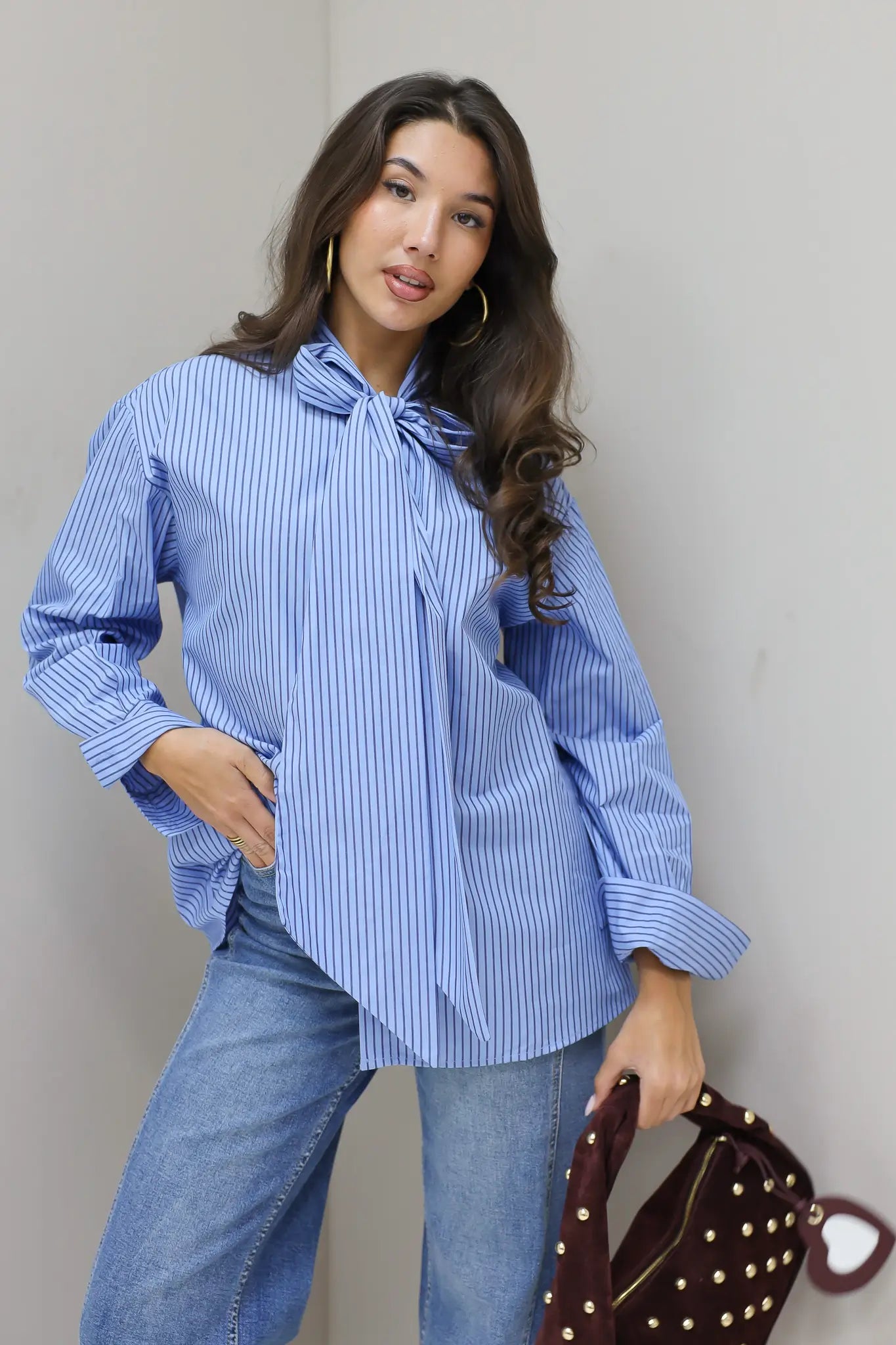 blauwe gestreepte blouse model vooraanzicht met tas in hand