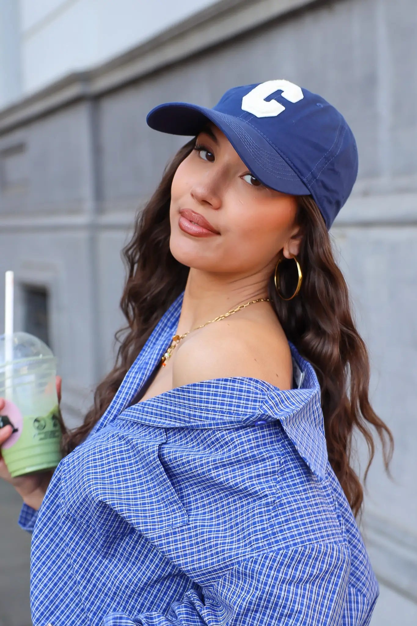 model draagt blauwe pet dames street style look