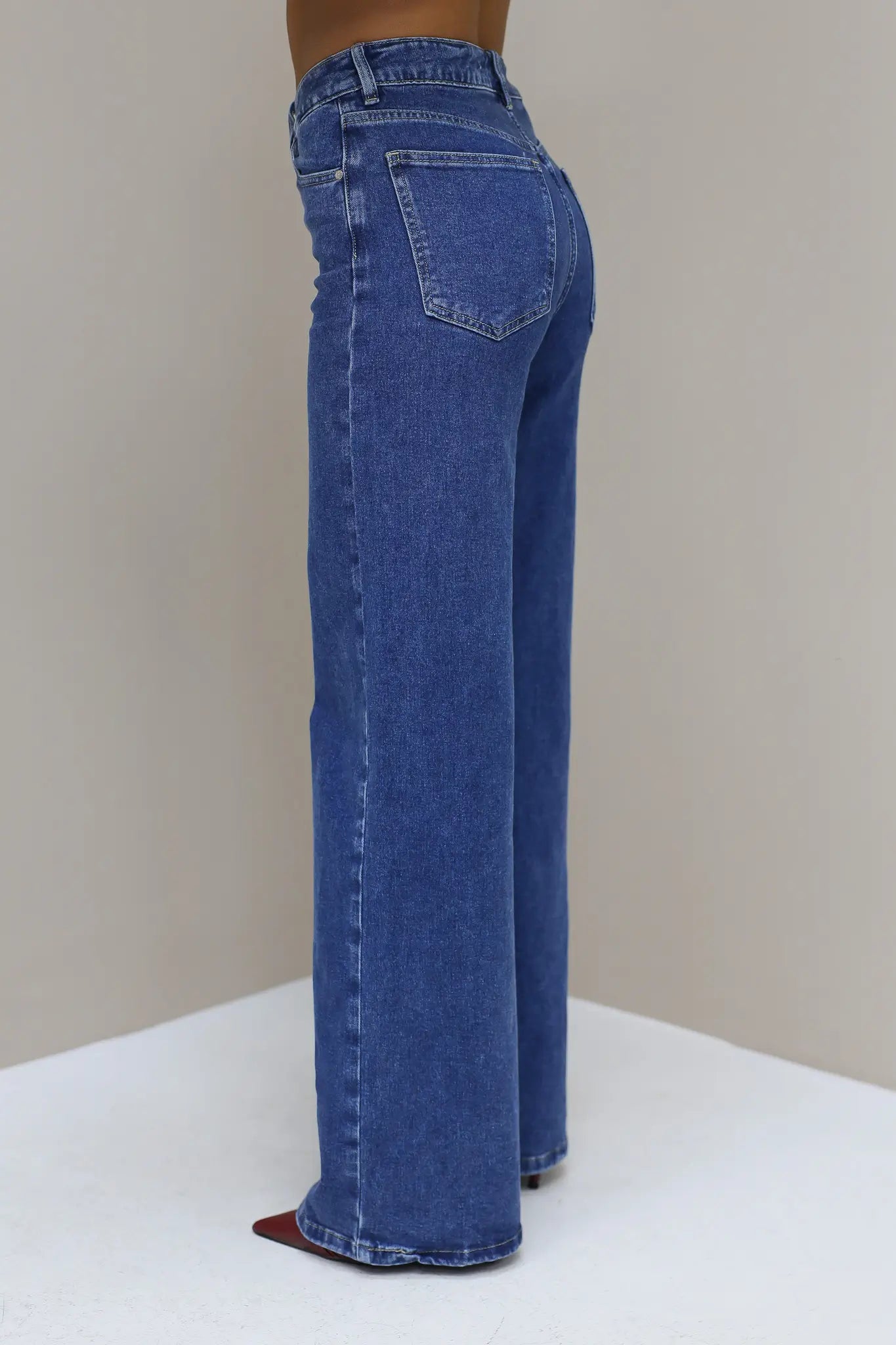 Blauwe wijde jeans vanaf de zijkant met lichte wassing