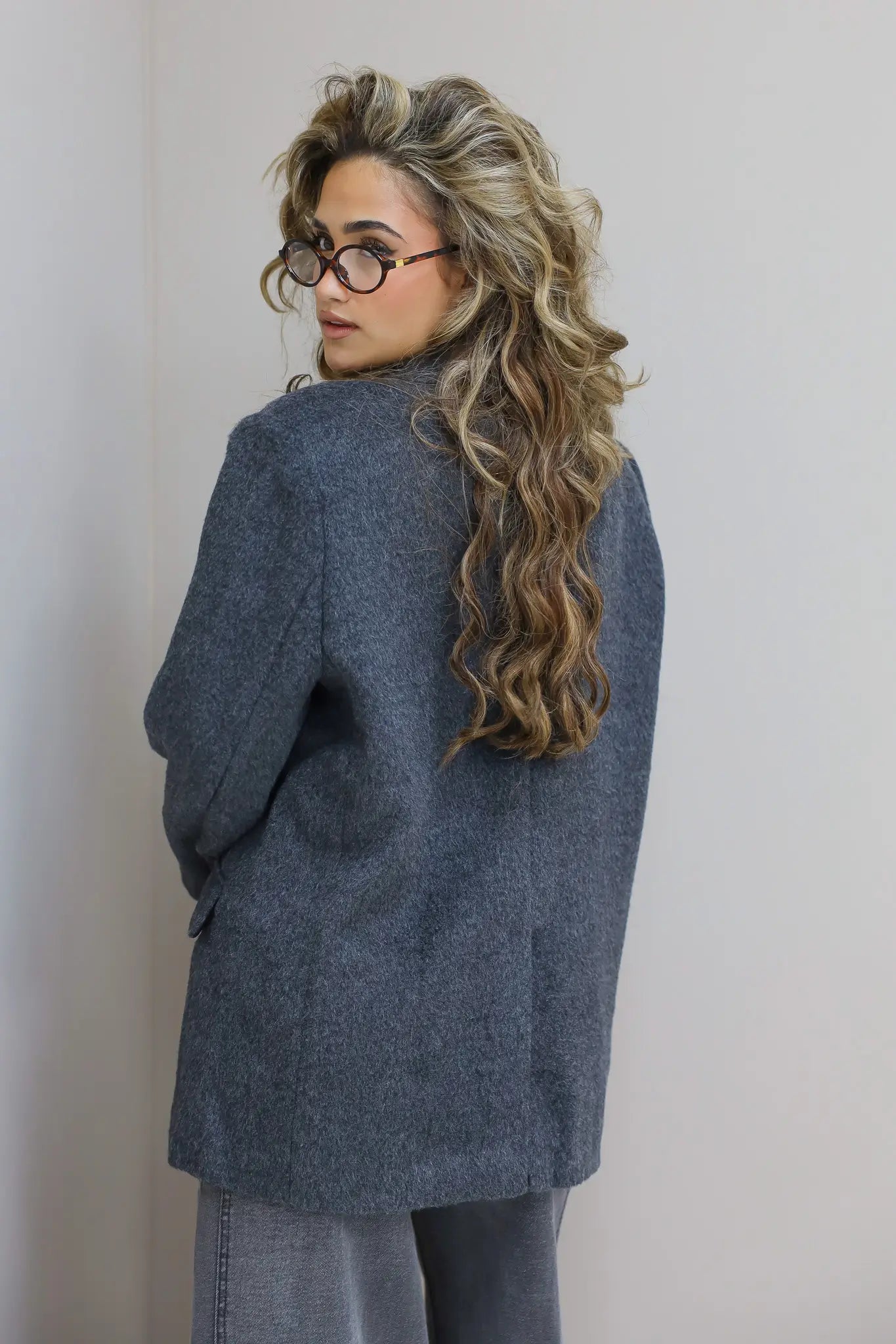 Achterkant van de blazer, focus op lengte en wolstructuur