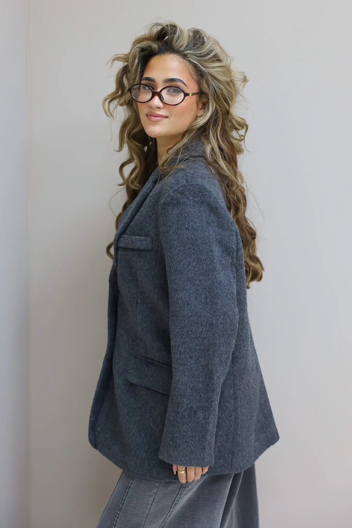 Zijkant van de blazer, model met bril en lange krullen