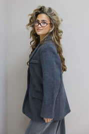 Zijkant van de blazer, model met bril en lange krullen