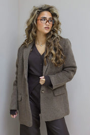 Model met taupe blazer en donkere top, rechte houding