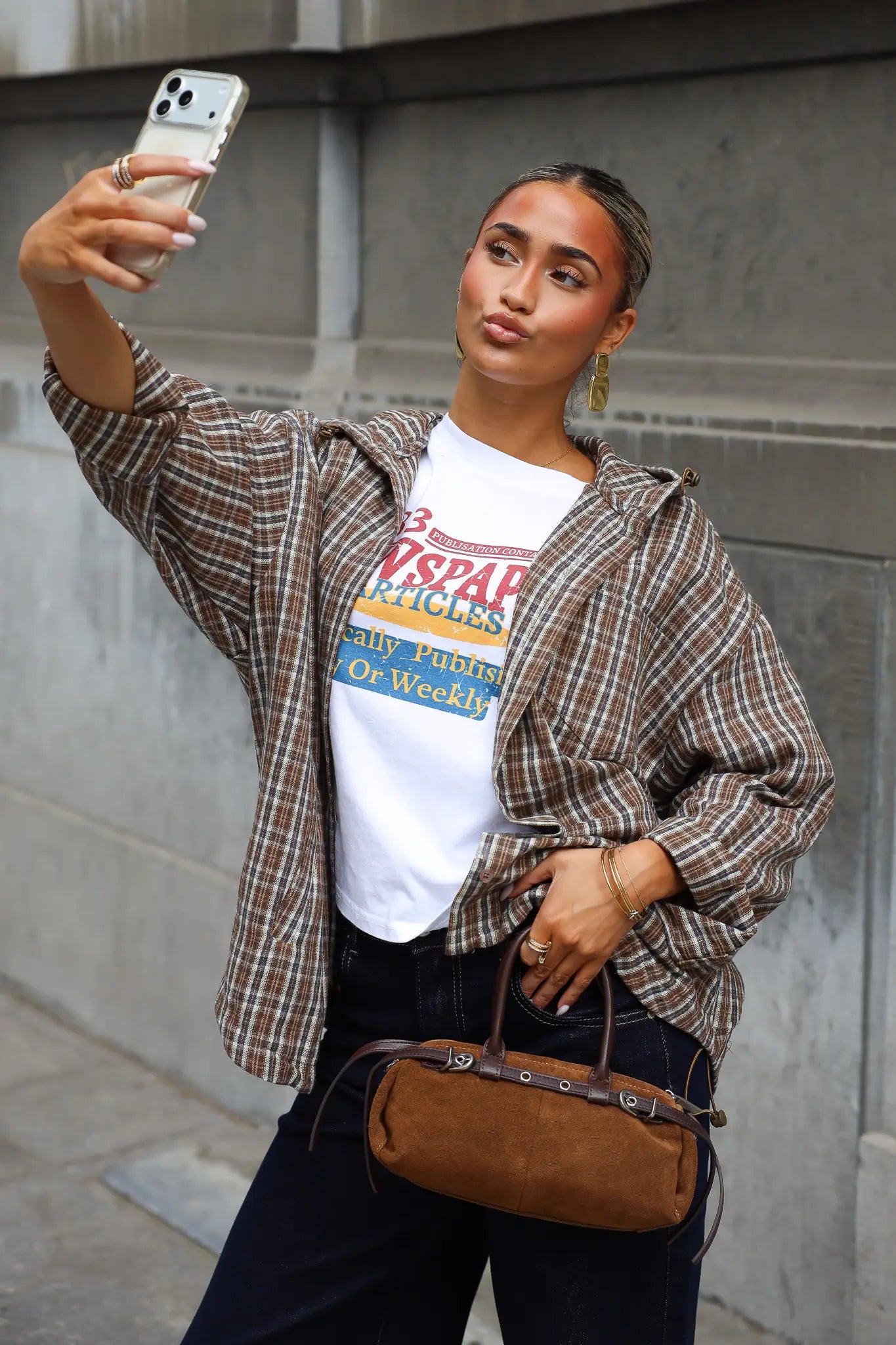 Camel blouse met ruitjes en capuchon open gedragen over een wit T-shirt met kleurrijke newspaper opdruk