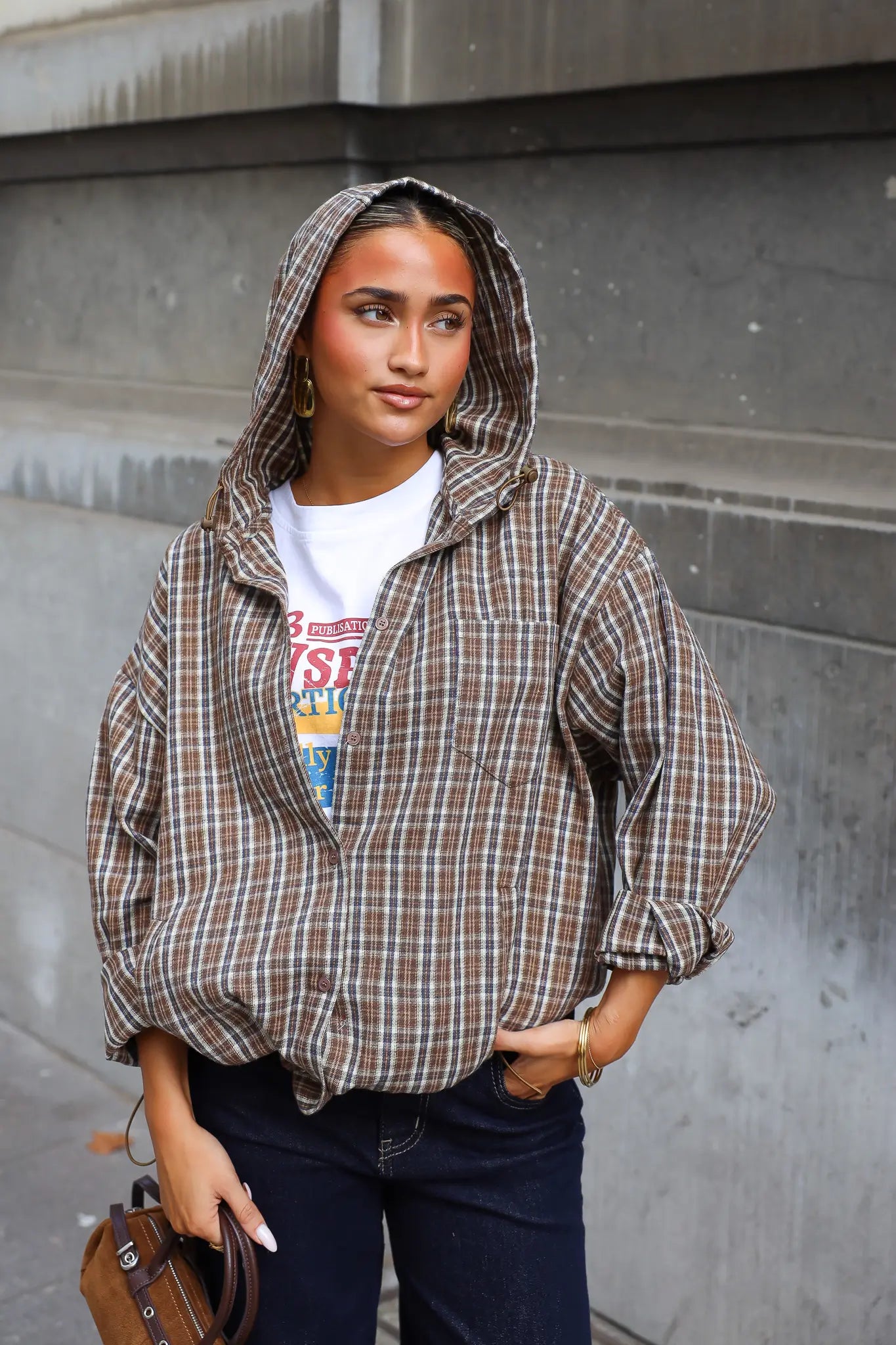 Camel geruite blouse met capuchon knoopsluiting en zakken gedragen over een wit T-shirt met donkere jeans