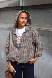 Camel geruite blouse met capuchon knoopsluiting en zakken gedragen over een wit T-shirt met donkere jeans